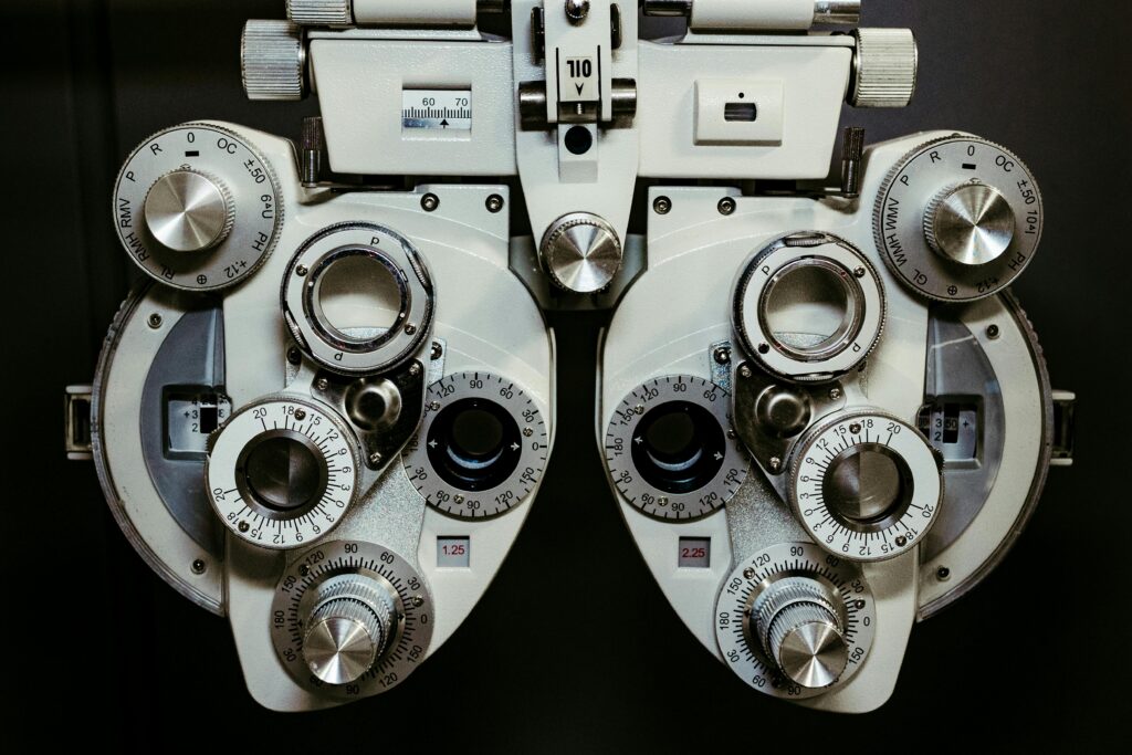 Detailed view of a vintage optometry phoropter with knobs and numbers, showcasing intricate technology.