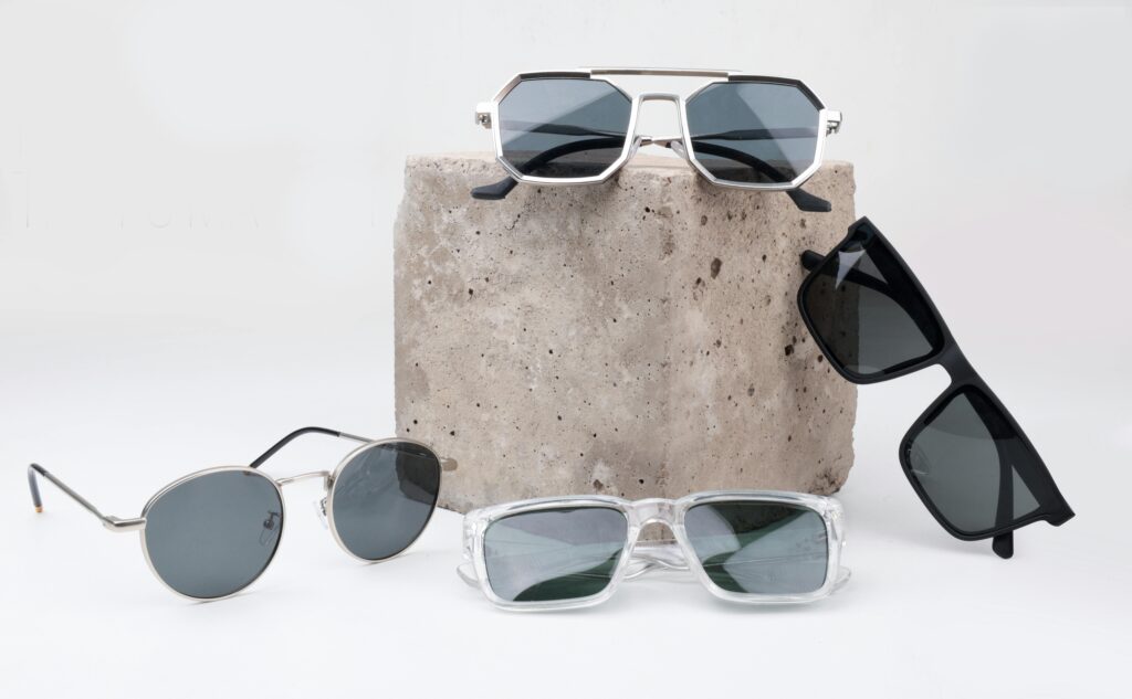 A diverse selection of sunglasses displayed on a textured concrete block, perfect for summer fashion.